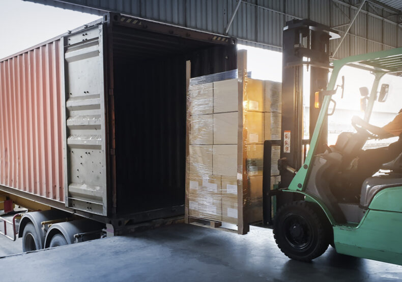 Forklift Tractor Loading Package Boxes into Cargo Container at Dock Warehouse is something a phoenix truck accident attorneys help with in truck accident claims 