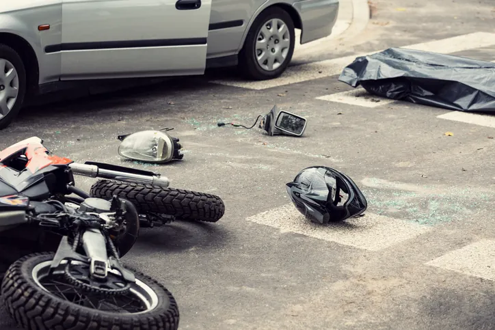 motorcycle accident, broken glass, motorcycle and helmet on the ground