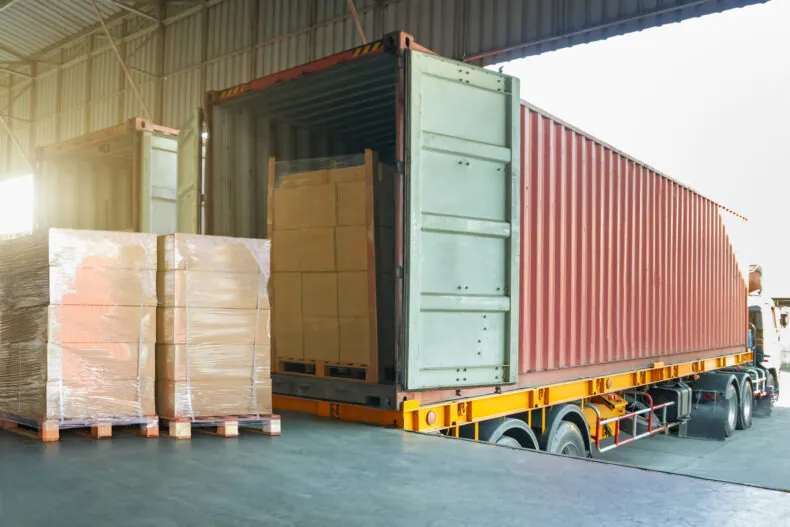 Package Boxes Wrapped Plastic Stacked on Pallets Loads into Container Trucks. Loading Dock Warehouse Shipping. Supply Chain, Shipment Goods. Freight Truck Logistic, Cargo Transport.