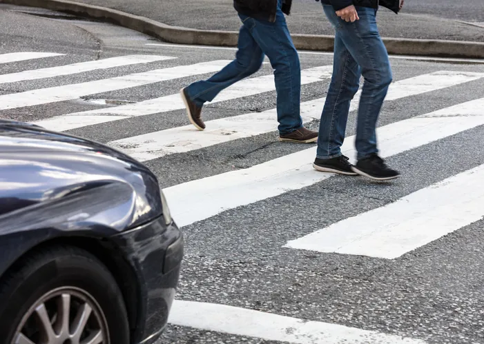 pedestrians crossing a crosswalk in front of a vehicle