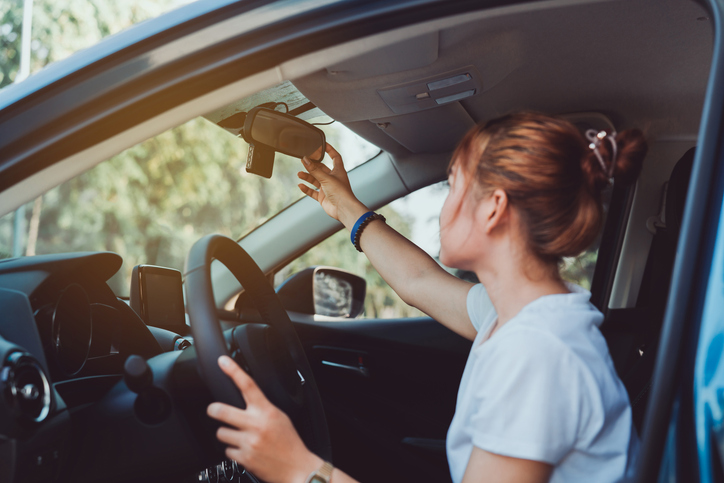 teen drivers adjusting mirror