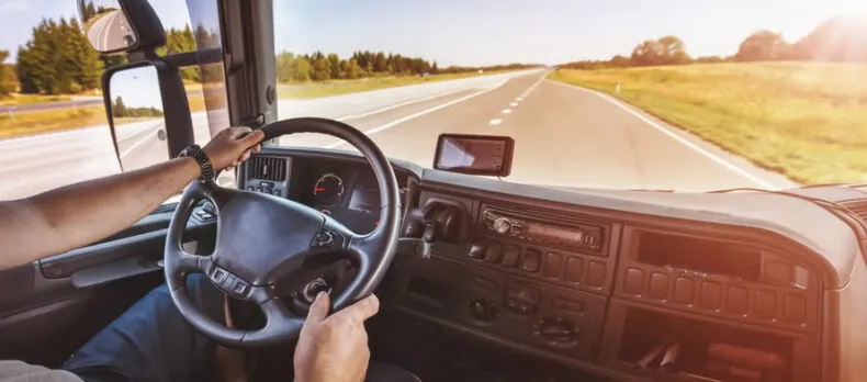 Driver of semi-truck sitting and driving his vehicle. Concept of shipping and delivering.