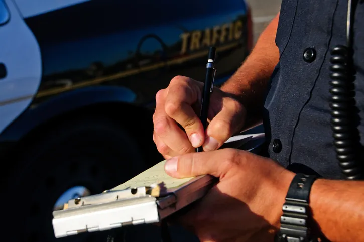 police officer writing ticket for traffic violation