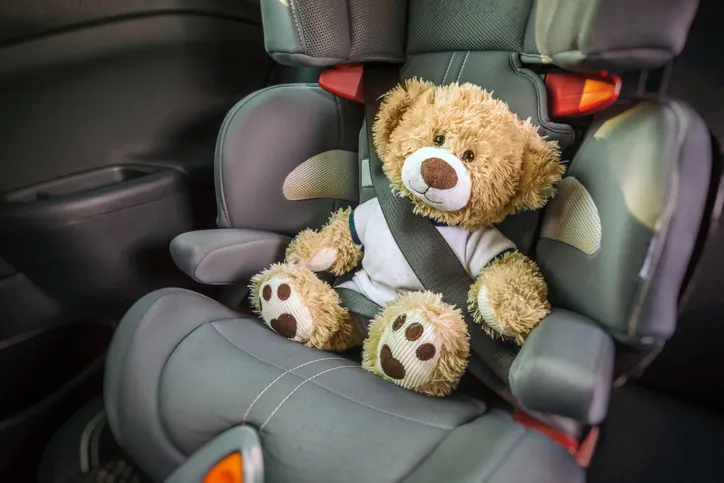 teddy bear secured in booster seat